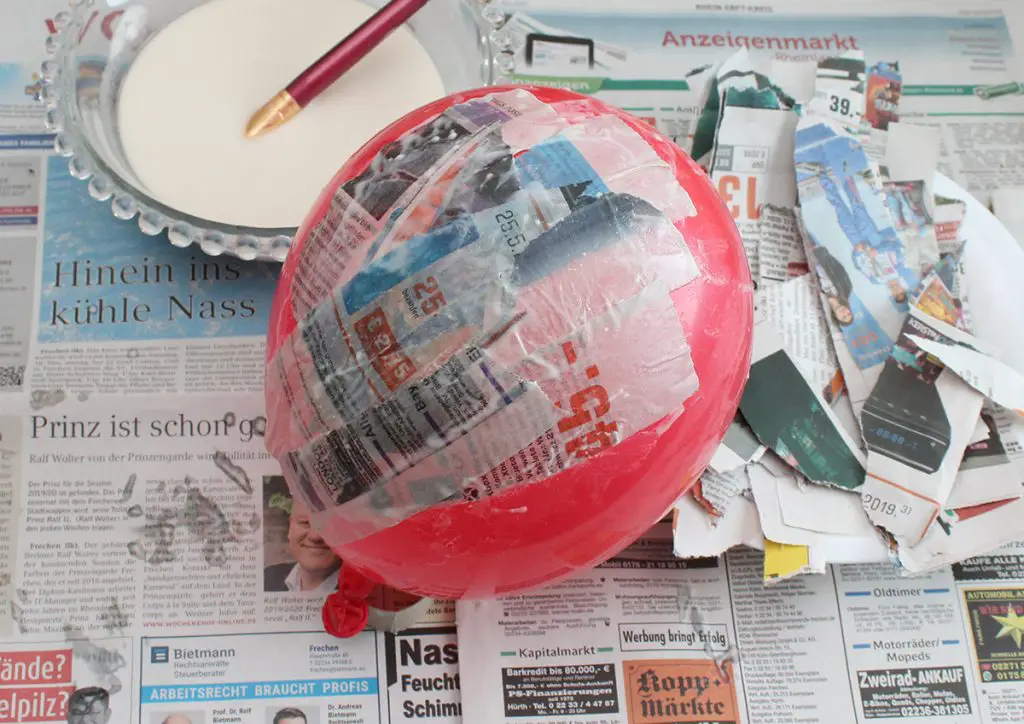 Luftballon mit Zeitungspapier bekleben